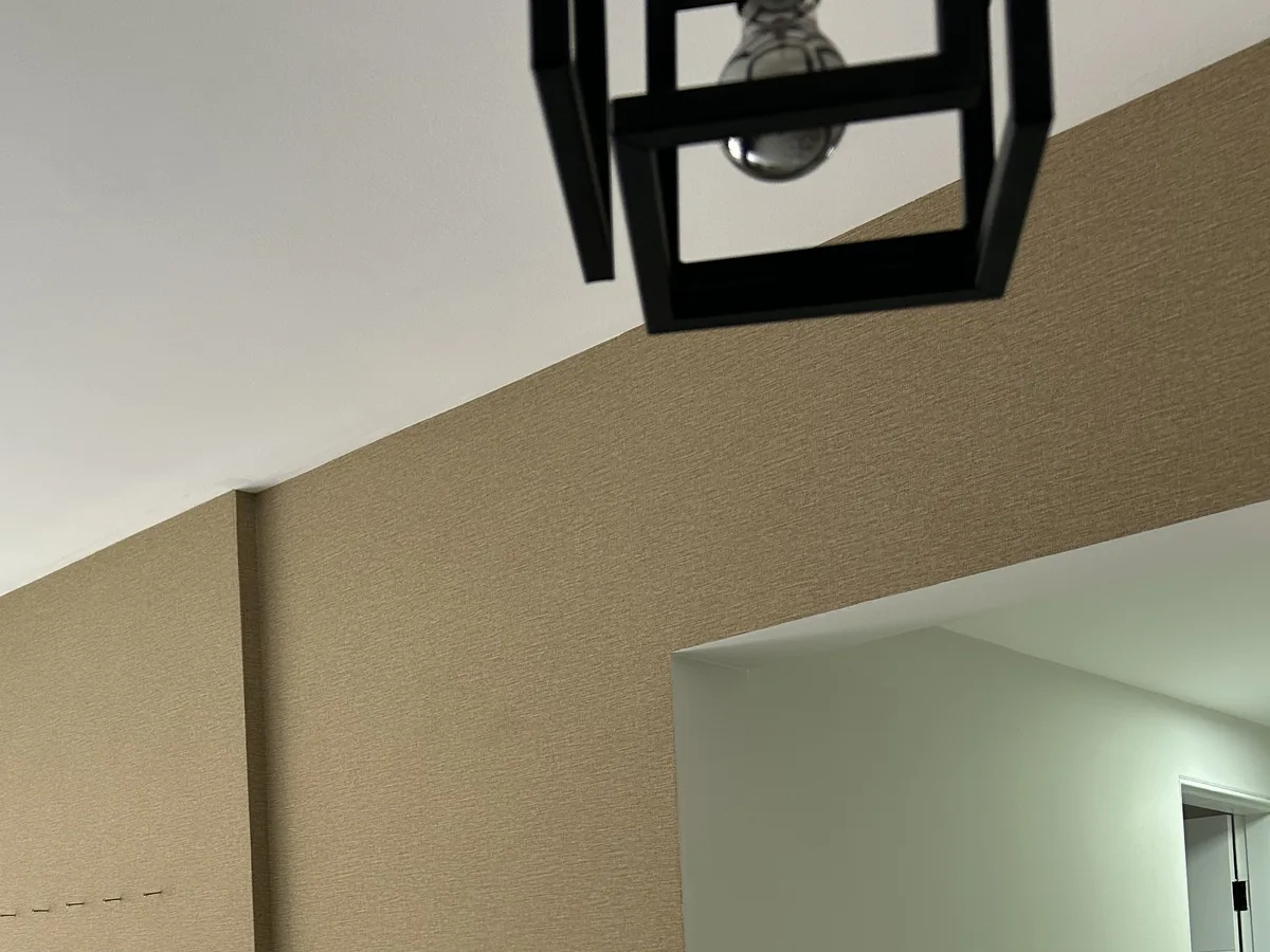 A mesma parede da sala revestida com papel em tom quente