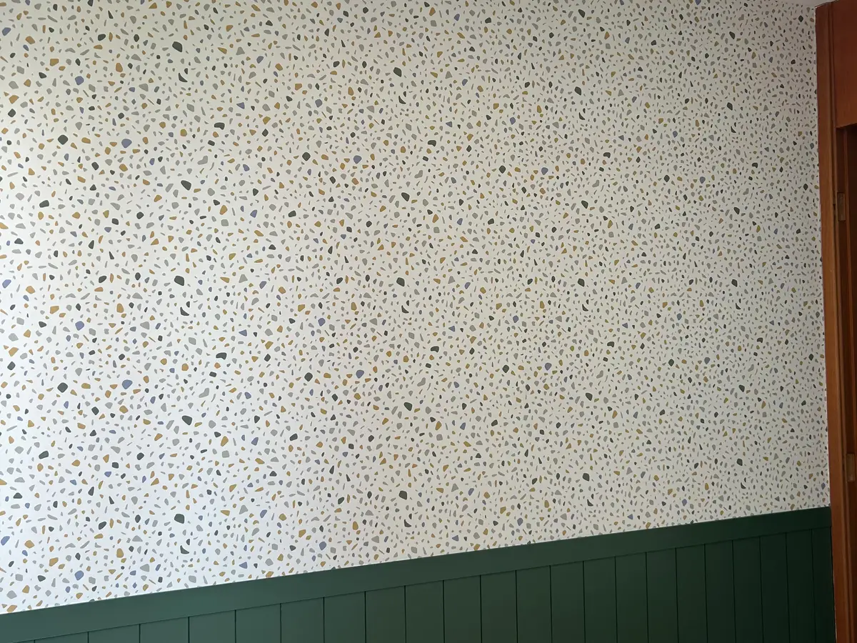 A mesma parede com papel de padrão granilite, acima do painel verde existente