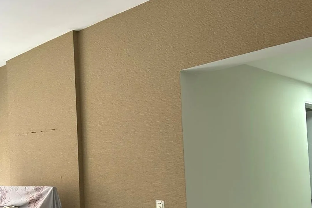 Parede de sala em Maceió com textura decorativa em tom areia, do rodapé ao teto