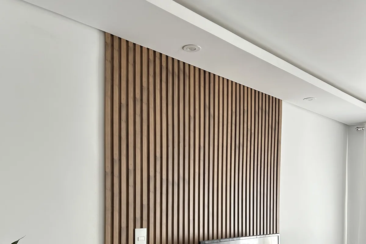 Painel ripado aplicado na parede da TV de uma sala