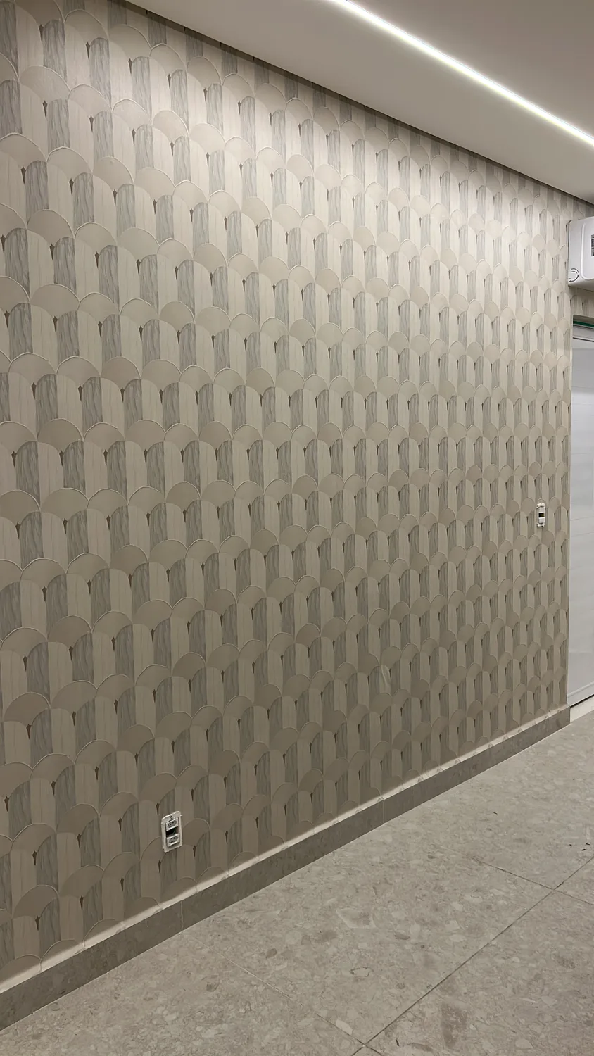 Papel de parede em padrão de escamas cobrindo a parede inteira de um corredor